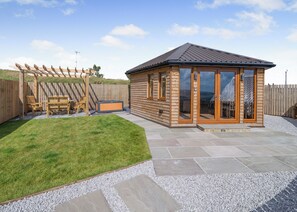 A wooden cabin with a patio, a hot tub, and a pergola with chairs. - 1 bedroom accommodation in Ripponden (Ripponden)