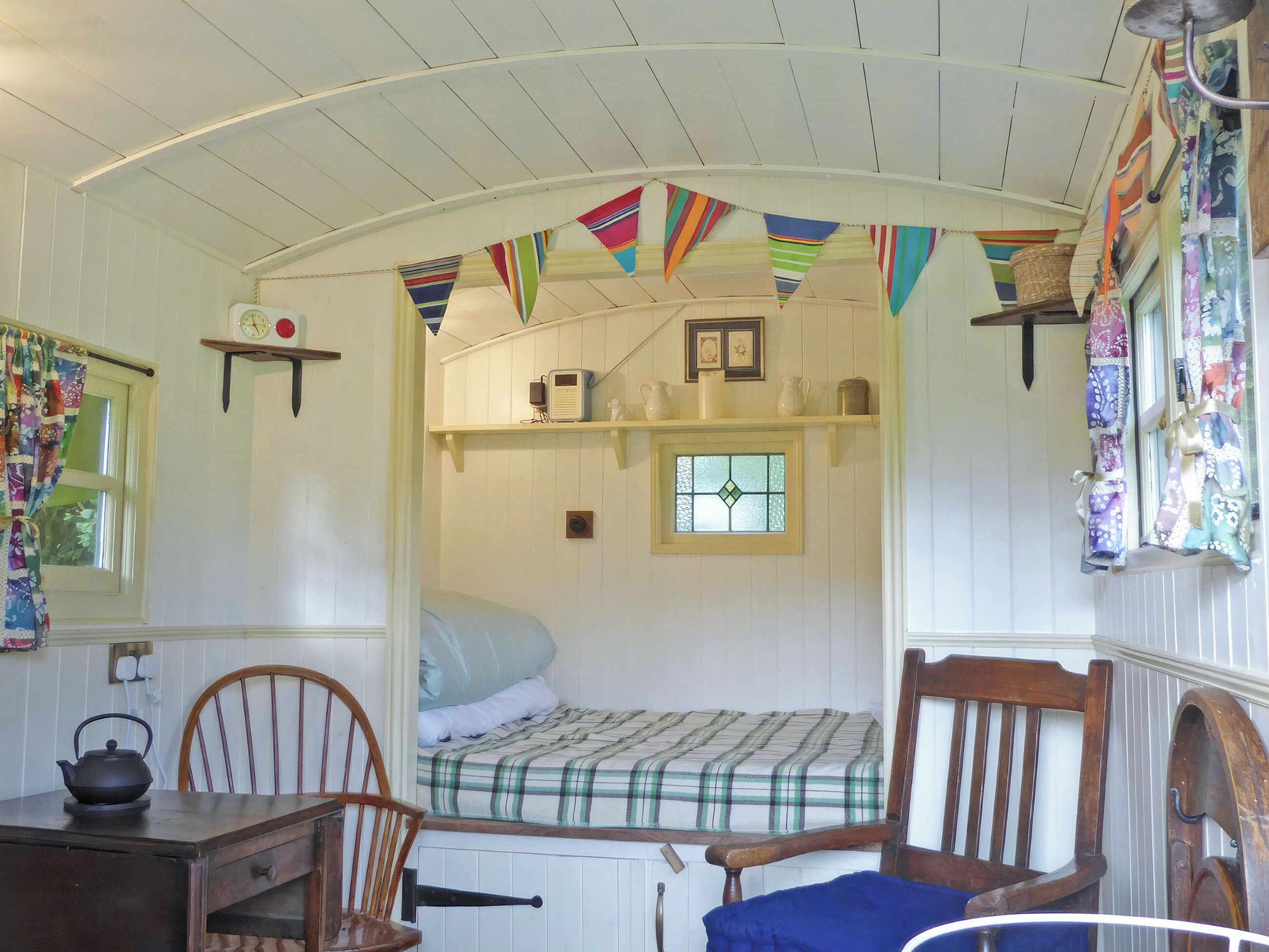 A cozy cabin-style room with a bunk bed, wooden furniture, and a small window.