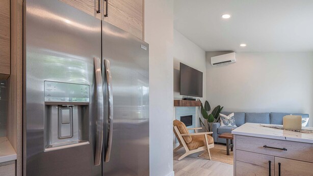 A modern kitchen with a stainless steel refrigerator, wooden cabinets, and a built-in water dispenser. - Blanchet Casita – Stylish 1BR Casita w/ Fire Pit & Patio (Vancouver)