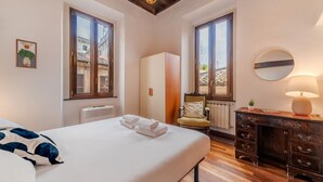 A bedroom with a bed, a dresser, a chair, and a radiator. - Vista Apartment in Trastevere (Roma)