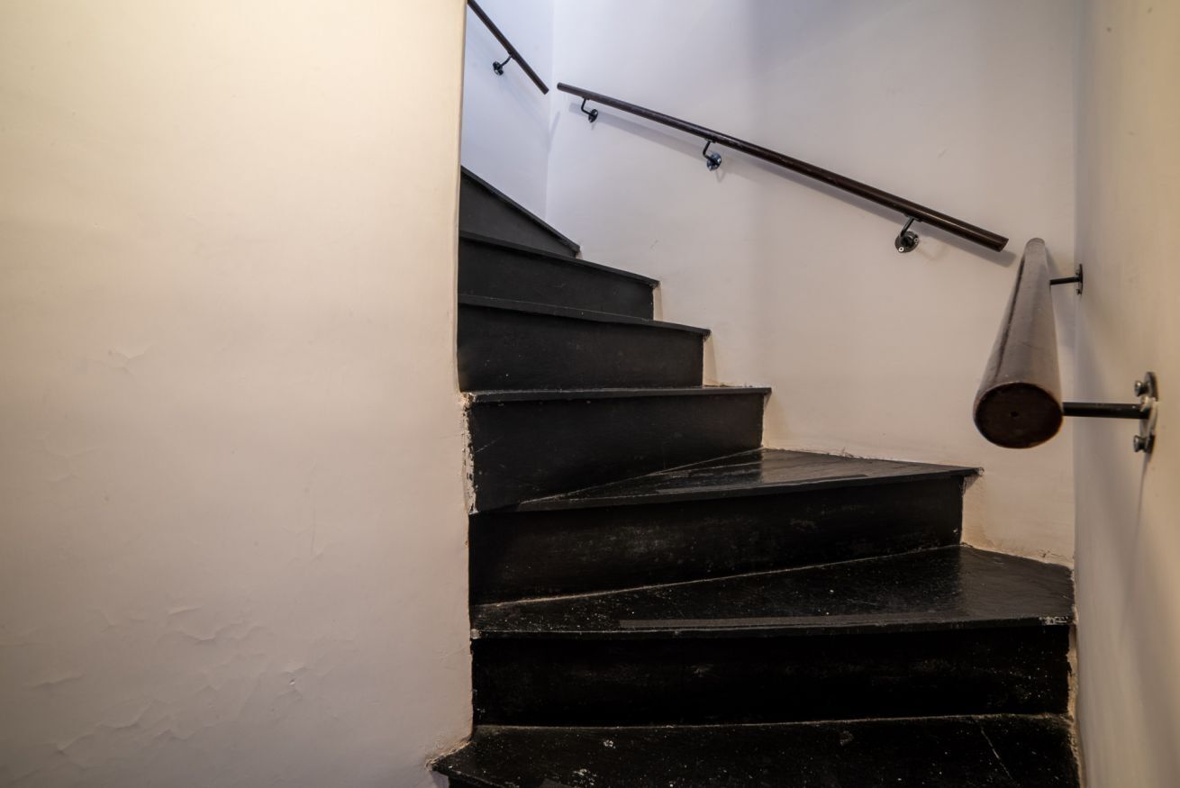 A staircase with black steps and metal handrails.