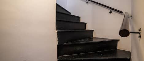 A staircase with black steps and metal handrails.