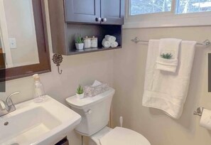 Een douche, handdoeken, zeep, toiletpapier