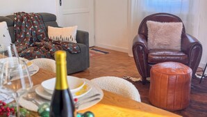 Un accogliente soggiorno con un divano grigio, una poltrona in pelle marrone e un tavolino in legno.