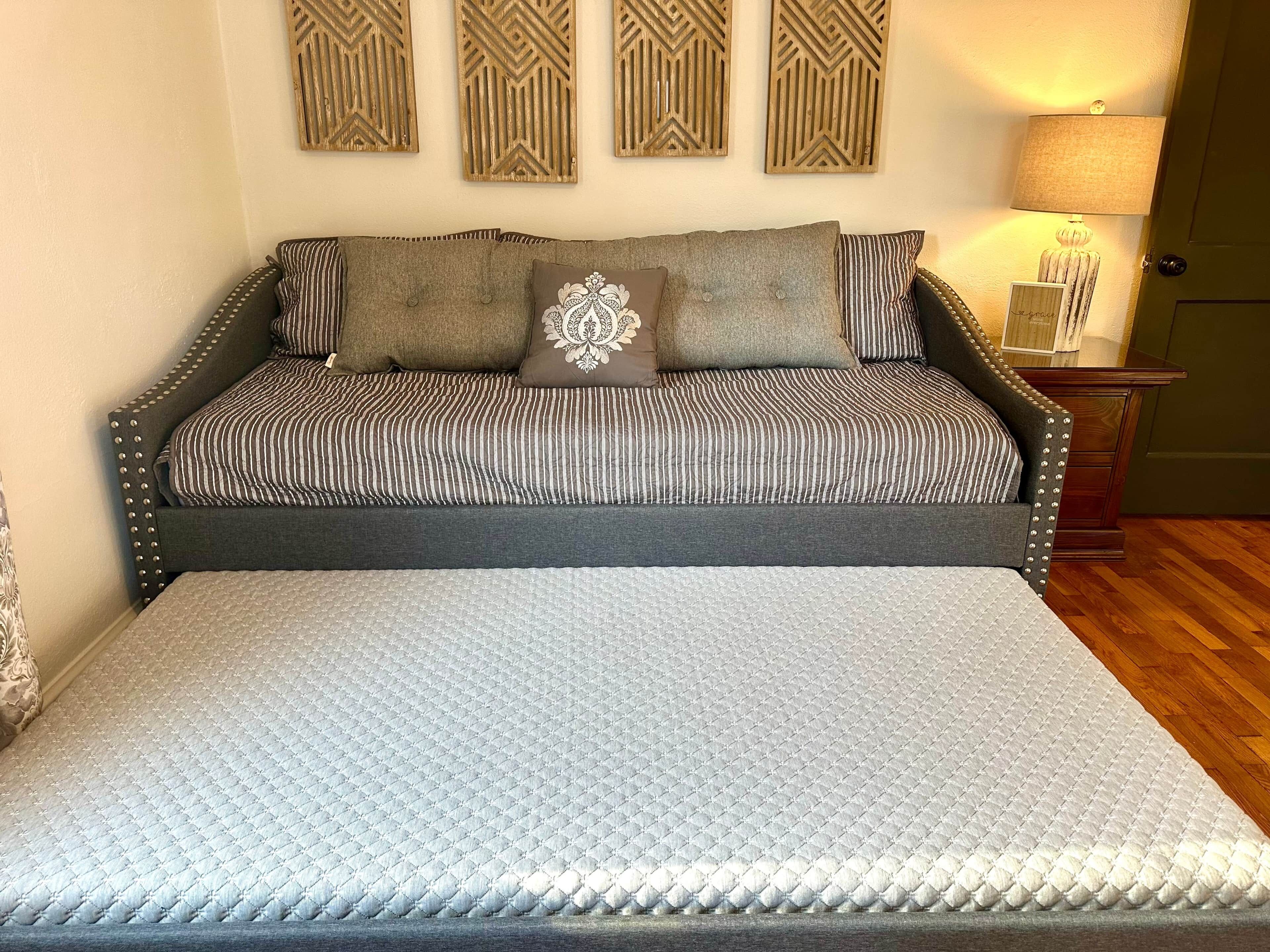 Une chambre à coucher comprenant un lit, un banc, une table de chevet et des éléments décoratifs sur les murs.