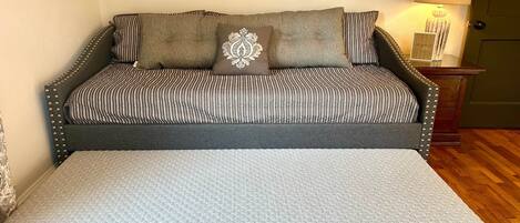 Une chambre à coucher comprenant un lit, un banc, une table de chevet et des éléments décoratifs sur les murs.