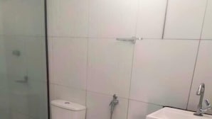 A bathroom with a toilet, bidet, and sink. - Pousada Sol e Mar Ilhéus (Ilhéus)