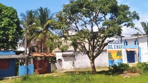 A building with a sign reading "POSADA SOL E MAR" and a tree in front. - Pousada Sol e Mar Ilhéus (Ilhéus)