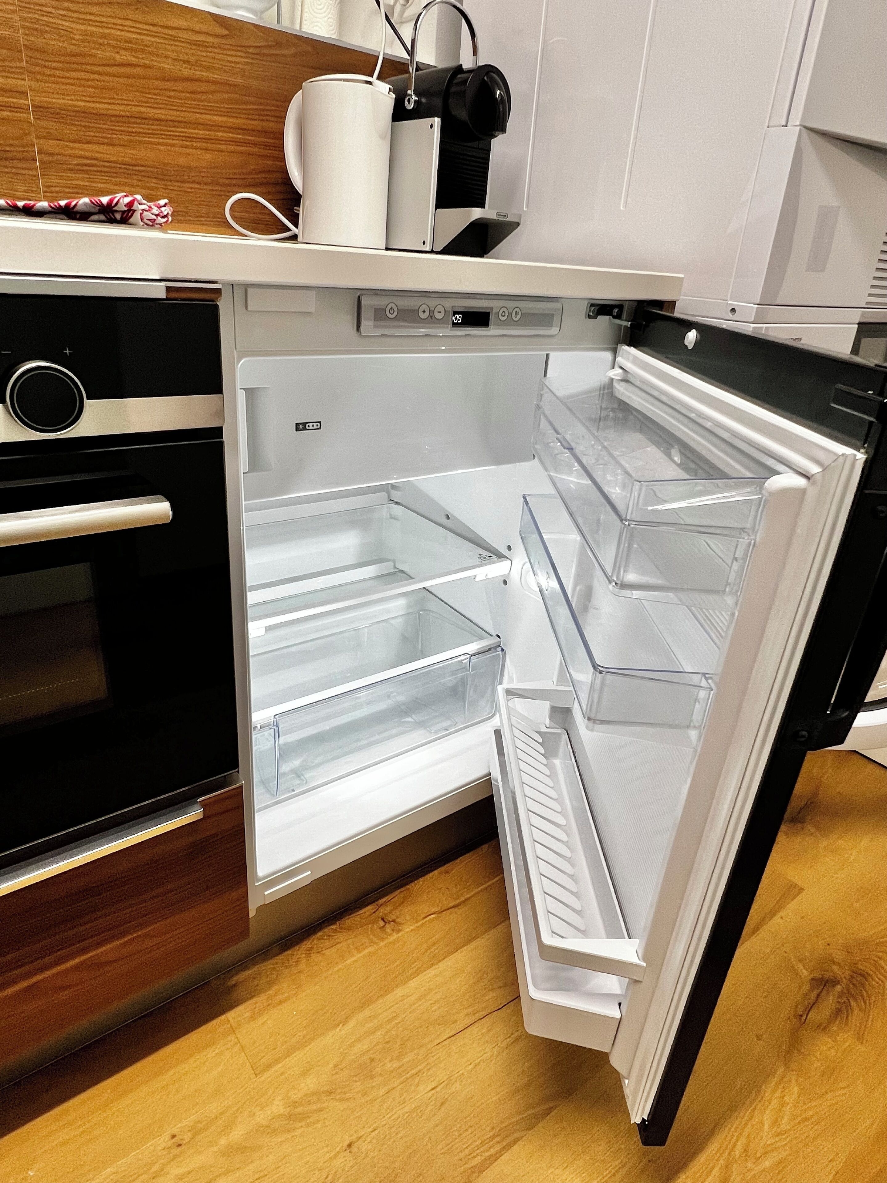 A modern kitchen with a built-in refrigerator, oven, and microwave.