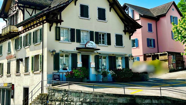 Ein traditionelles europäisches Gebäude mit einem Giebeldach, einem Schild für 'da Franco Restaurant' und einer Steintreppe, die zum Eingang führt.