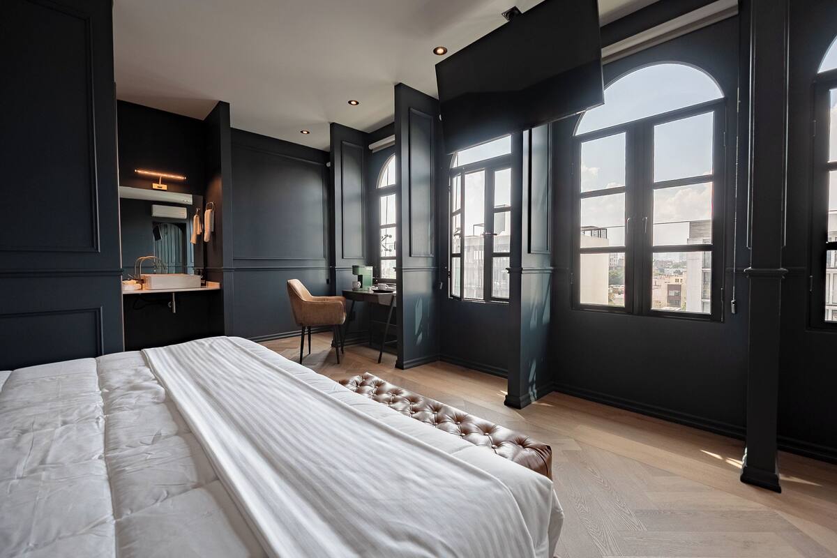 Un dormitorio moderno con una cama grande, un escritorio y una silla.