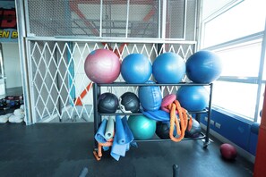 Une salle de sport équipée de matériel d’exercice, notamment des ballons et des tapis, et dotée d’une fenêtre offrant une vue agréable.