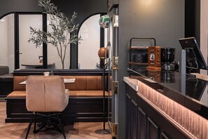 A bar area with a leather booth, a stool, and a coffee machine. - The Sapphire Room (Mexico City)