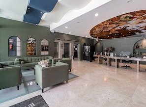 A modern lobby with seating areas, a reception desk, and a large decorative ceiling. - The Sapphire Room (Mexico City)