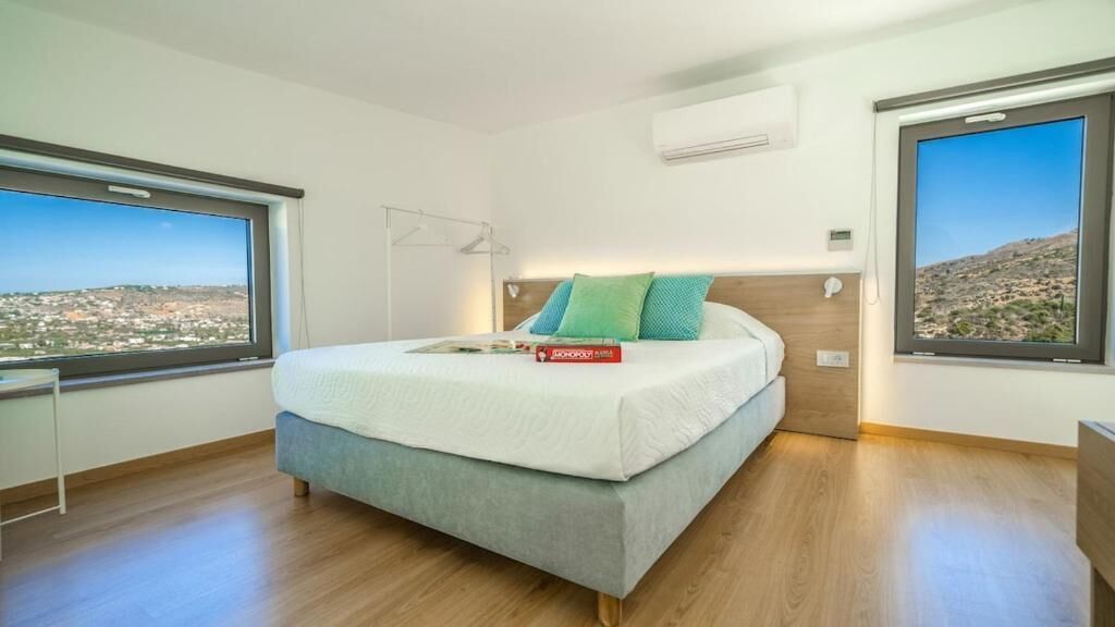 Une chambre à coucher avec un lit, une fenêtre et une vue sur la ville.