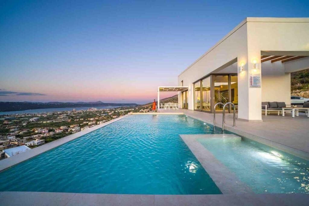 Un hotel moderno con piscina y vistas al mar.