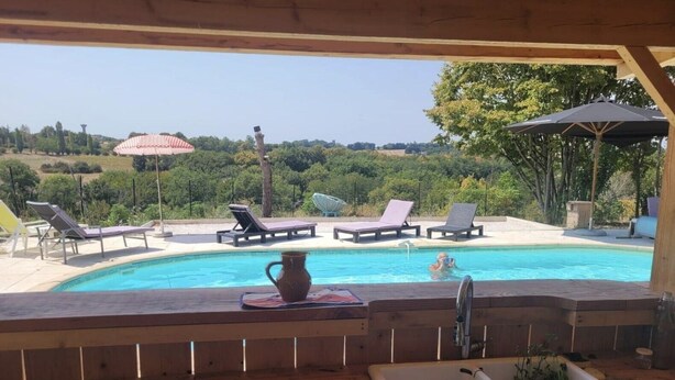 A poolside area with lounge chairs, a wooden deck, a sink, and a view of a natural landscape. - Holiday Home 'La P'tite Maiz' with Shared Pool, Private Terrace & Wi-Fi (Bourg-de-Visa)