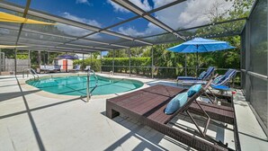 Une piscine extérieure couverte, dotée de chaises longues et de parasols.