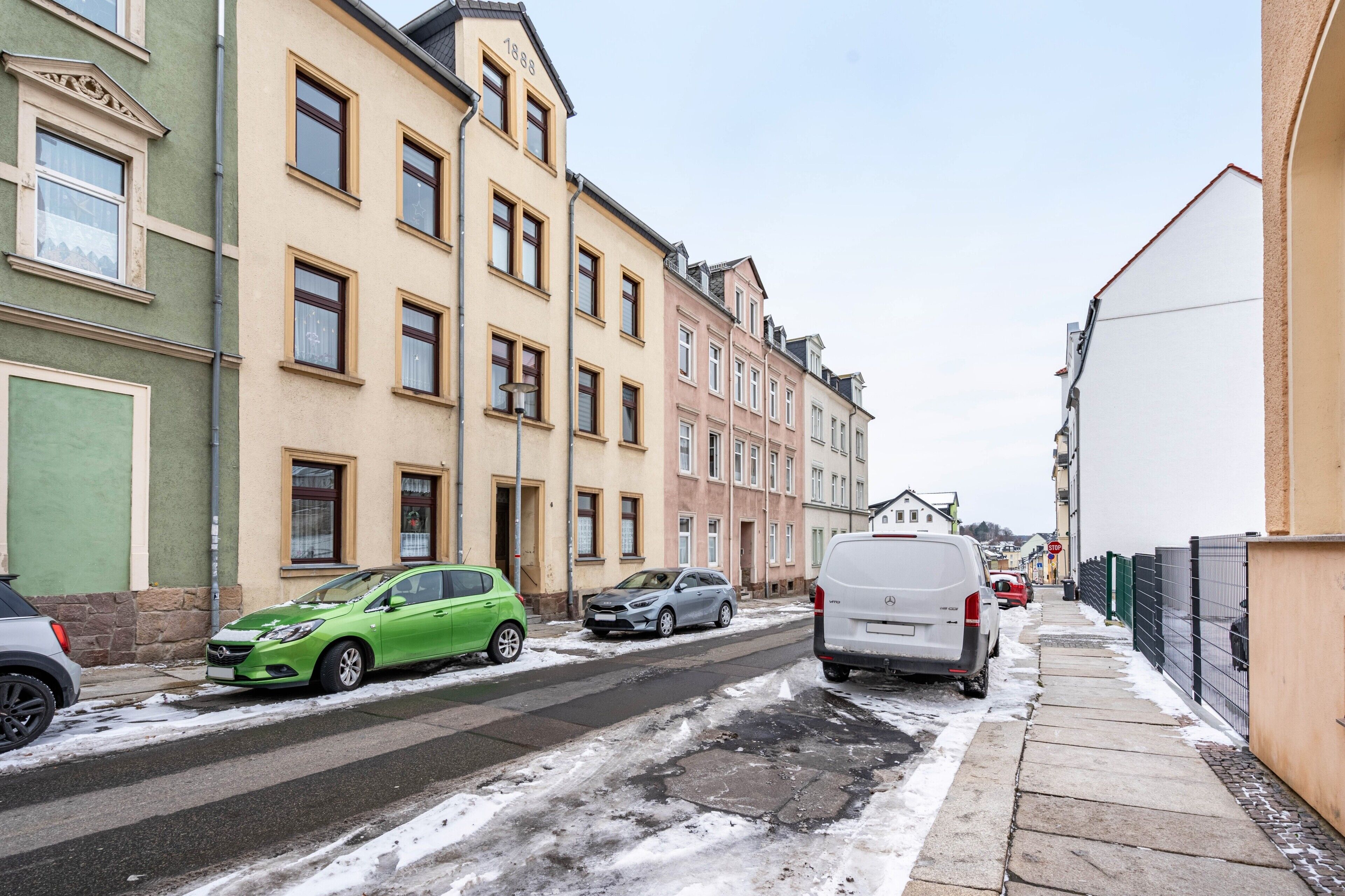 Eine Straße mit parkenden Autos und Gebäuden.