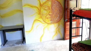 A room with a mural of a sun and a bench.