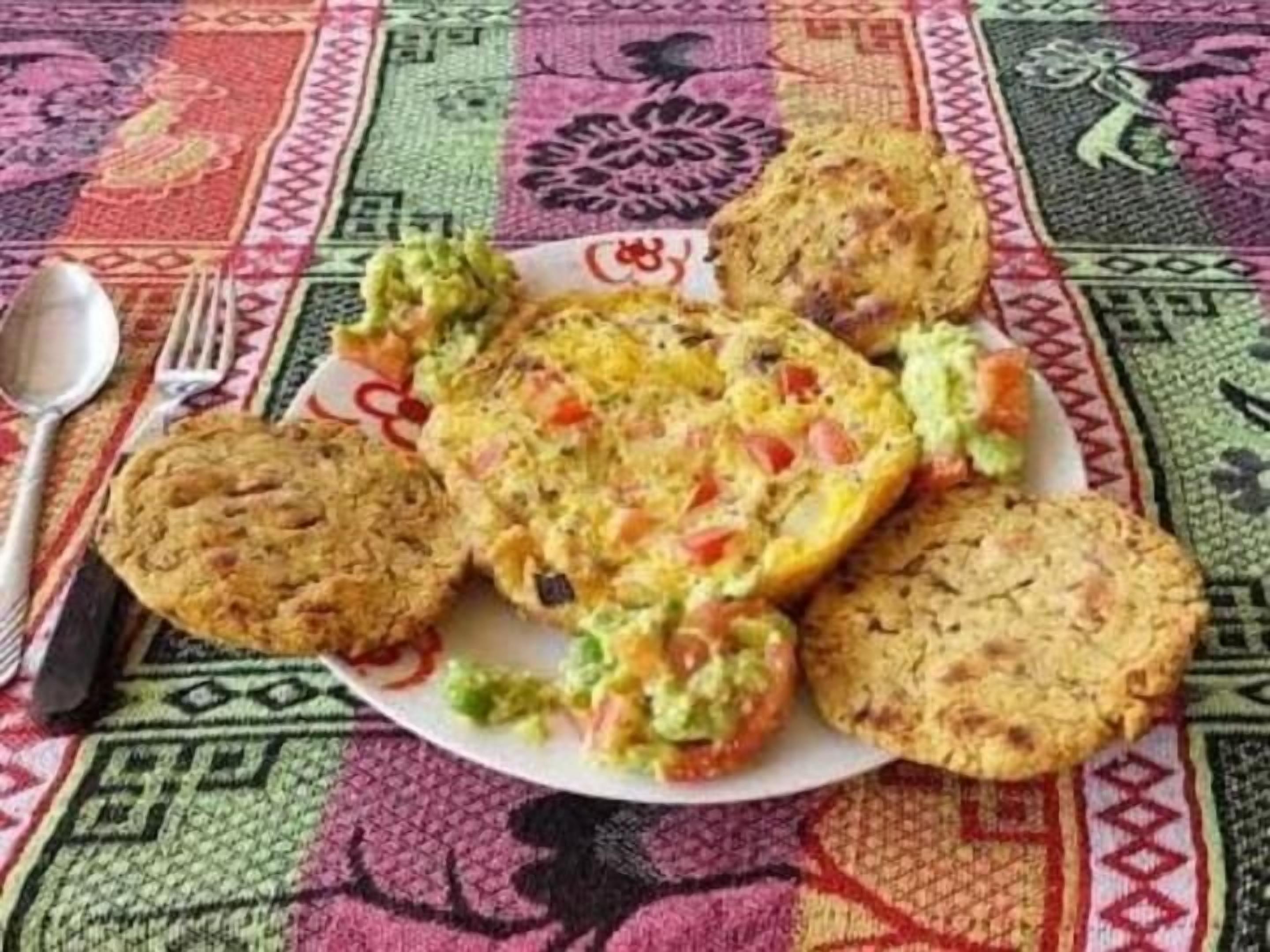 Un piatto con diversi alimenti, tra cui biscotti e una pietanza con verdure e una crema.