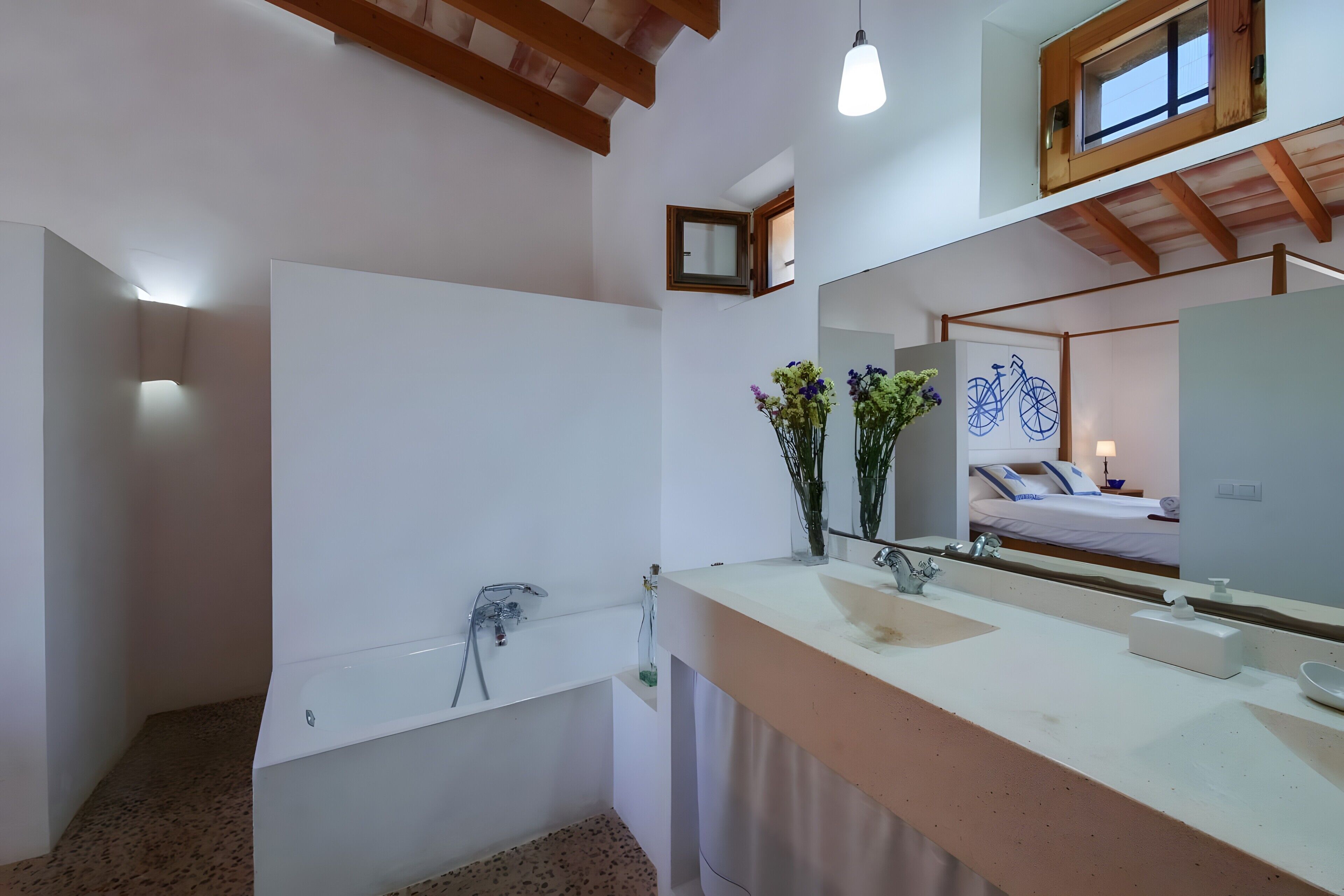 Un baño moderno con bañera, un espejo grande y un tocador con lavabo.