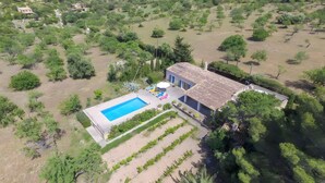 Vue aérienne d’une propriété comprenant une piscine, une maison et un espace verdoyant.