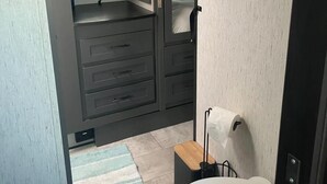 Un baño moderno y funcional con inodoro, lavabo y espejo.