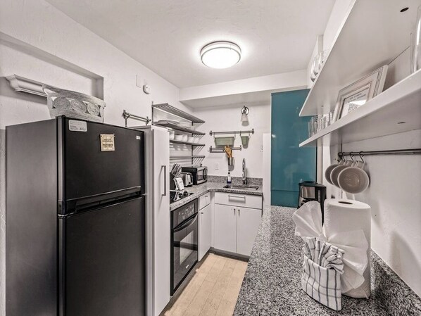 A compact kitchen with a black refrigerator, white cabinets, a microwave, and a sink. - Center of Town|Walk Everywhere|Free Shuttle & Prkg (Breckenridge)