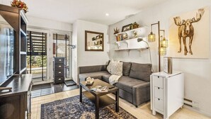 A modern living room with a sofa, coffee table, and a bookshelf. - Prime Main Street location in Breckenridge (Breckenridge)