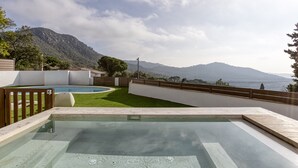 Una piscina con vistas a las montañas y al mar.