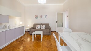 A modern living room with a sofa, a coffee table, and a dining table. - Sea View Central Apartment by Wonderful Italy (Sanremo)