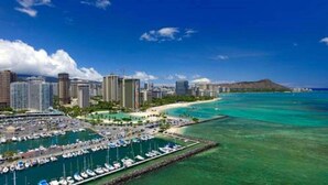 A coastal cityscape with a marina, high-rise buildings, and a mountain in the background. - 7th Fl Ilikai | AC | Pool (Honolulu)