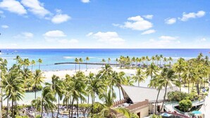 A beach resort with palm trees, a pier, and a view of the ocean. - 7th Fl Ilikai | AC | Pool (Honolulu)