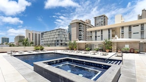 A rooftop pool with multiple levels of balconies, surrounded by a landscaped area with potted plants. - 7th Fl Aloha Lani  | Lanai | AC | Parking | Pool (Honolulu)