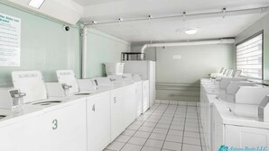 A laundry facility with multiple washing machines and dryers, numbered from 3 to 5, in a clean and organized layout. - 7th Fl Aloha Lani  | Lanai | AC | Parking | Pool (Honolulu)