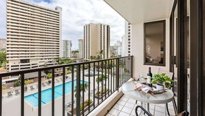 Balkon med udsigt over swimmingpool og omkringliggende bygninger.