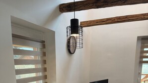 A dining area with a white table, red chairs, and a black TV stand. - The Hungarian Valley (Szellő)