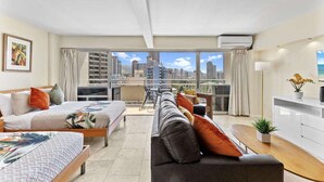 A modern hotel room with a balcony, a sofa, a bed, and a dining area. - Ilikai 14th Fl Studio | City View | AC | Pool (Honolulu)