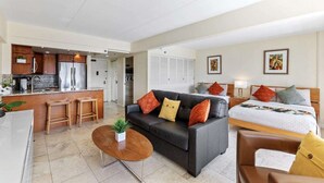 A modern hotel room with a kitchenette, a sofa, a bed, and a dining area. - Ilikai 14th Fl Studio | City View | AC | Pool (Honolulu)