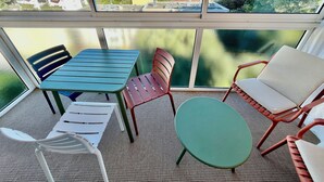 A balcony with a table and chairs, a view of a coastal town, and a clear sky. - Sea view, calm and comfort in the village (Hyères)
