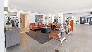 A spacious living area with a sofa set, coffee table, and a dining table with chairs. There is a kitchen area visible to the left. - 3rd Fl Palms Waikiki Studio Overlooking the Pool | Parking (Honolulu)