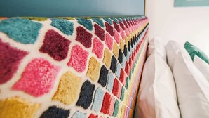 Un mur aux couleurs vives et orné de motifs, avec un plafond bleu et une enseigne portant un texte.