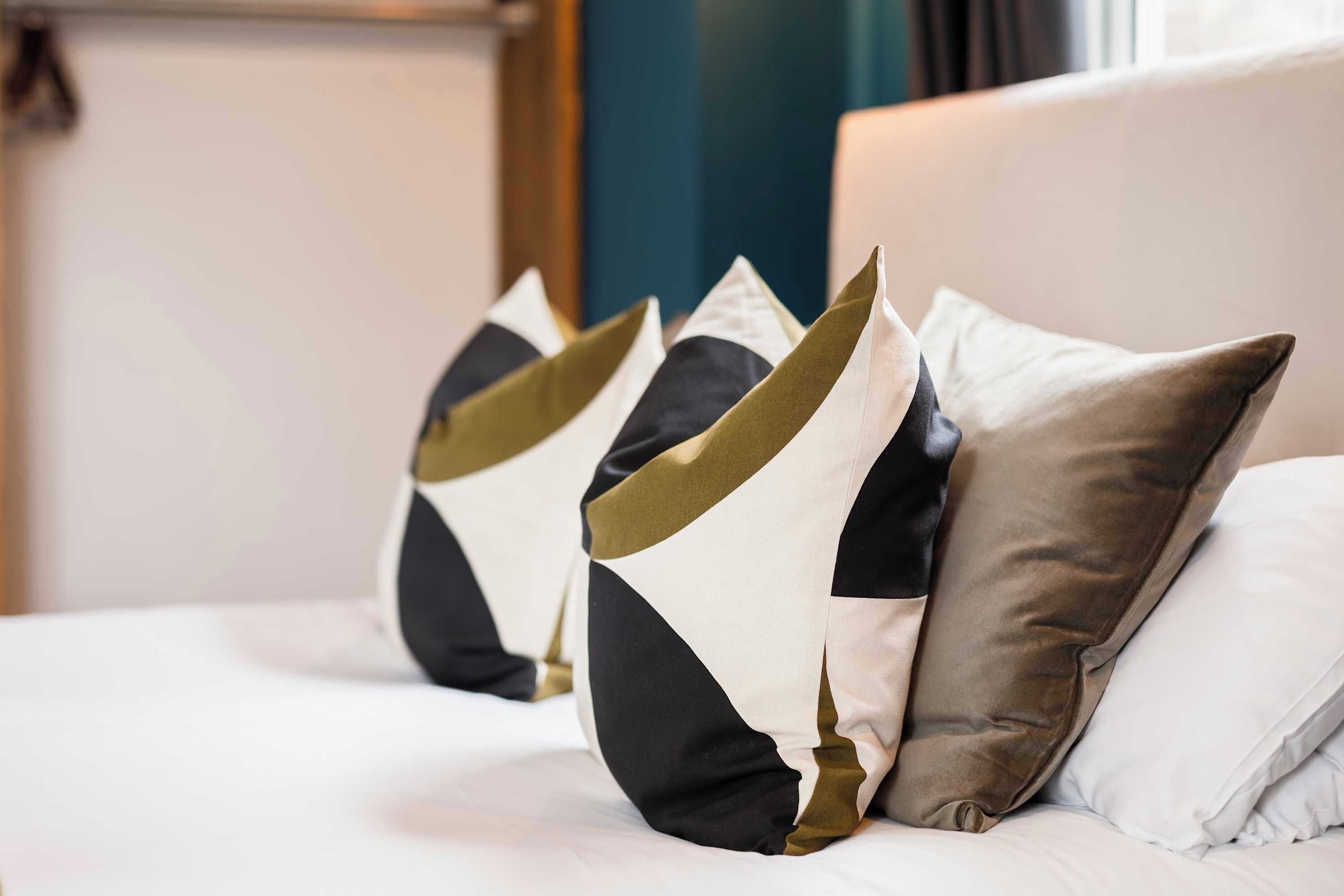 Una cama con almohadas en una habitación de hotel.