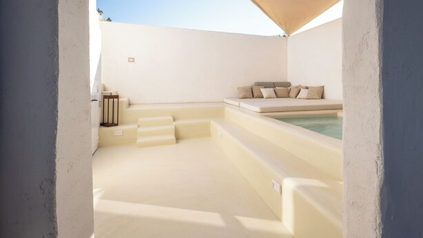 Un área de spa con un jacuzzi, asientos y escalones que llevan al mismo.