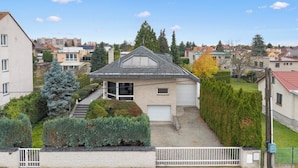 Ein Wohnhaus mit Garage, einer überdachten Veranda und einem gepflegten Garten.
