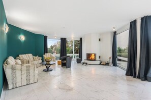 A spacious living area with a fireplace, seating, and large windows. - Black Dragon Castle (Prague 20)