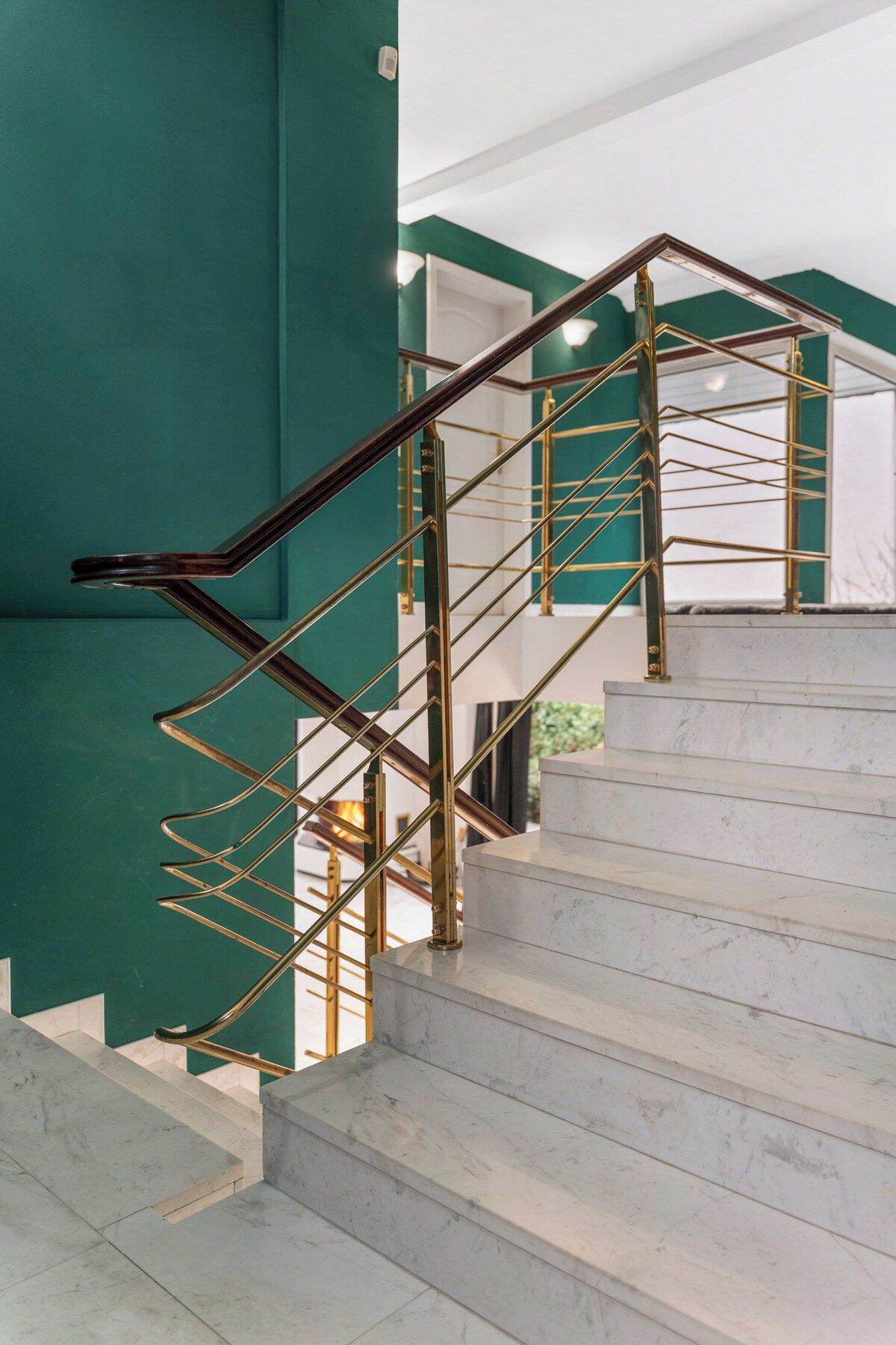 Eine moderne Treppe mit Marmorstufen und einer Geländer aus goldenem Metall.