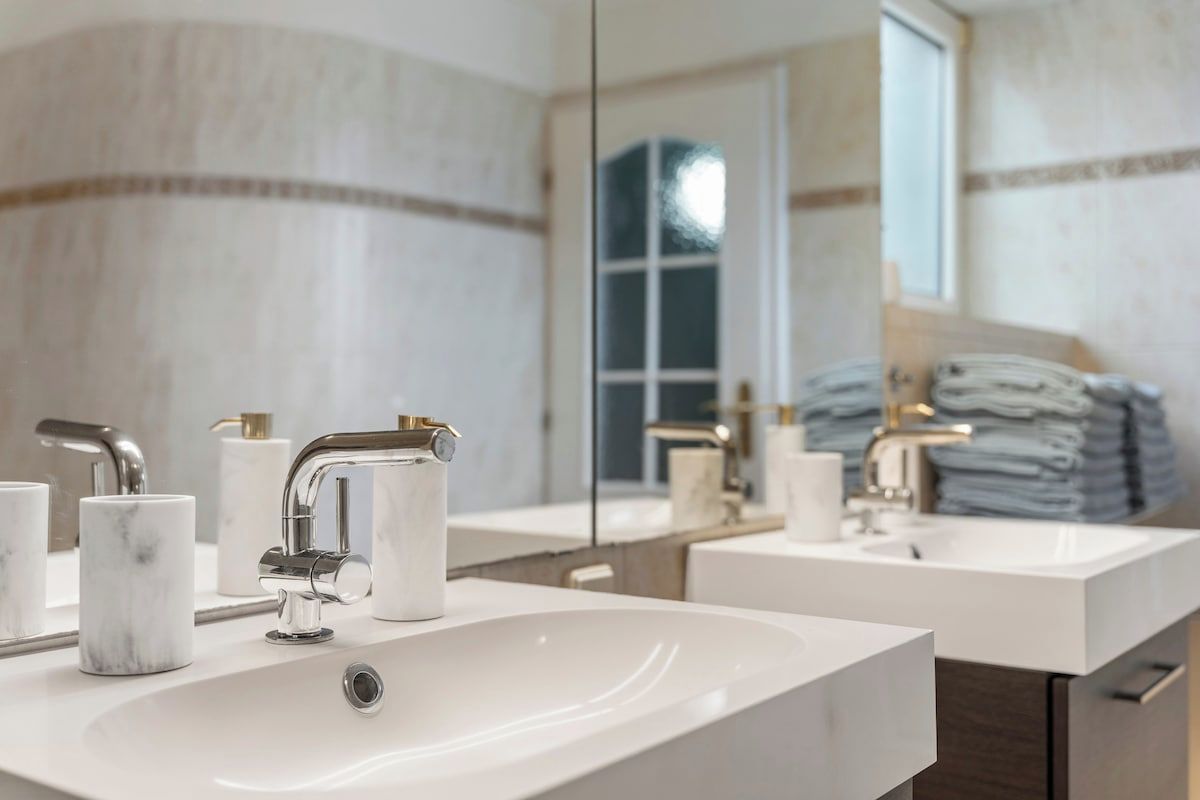 Une salle de bain avec deux lavabos, un miroir et une fenêtre.