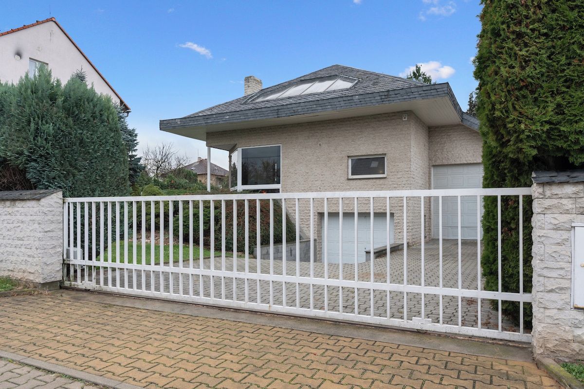 Una proprietà residenziale con ingresso carrabile e vialetto lastricato, e una casa con tetto a falde.